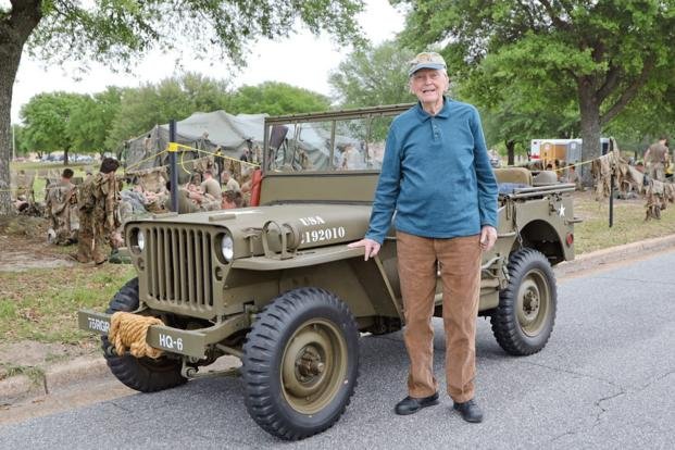 Korean War Veteran standing next to a military vehicle